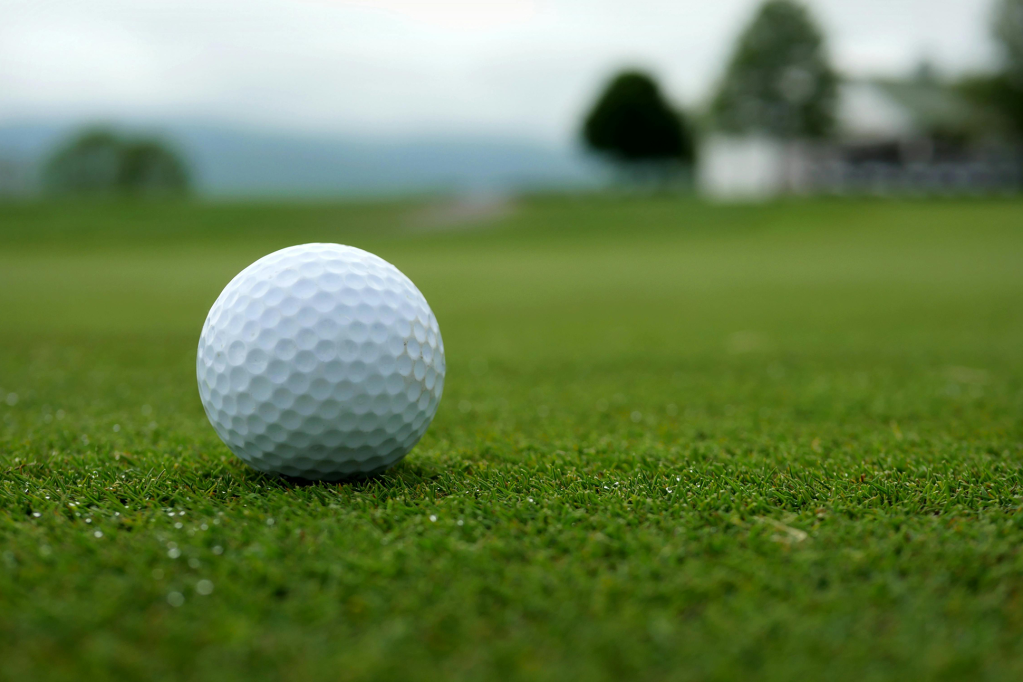 STOCK IMAGE - GOLF BALL ON GOLF COURSE GREEN