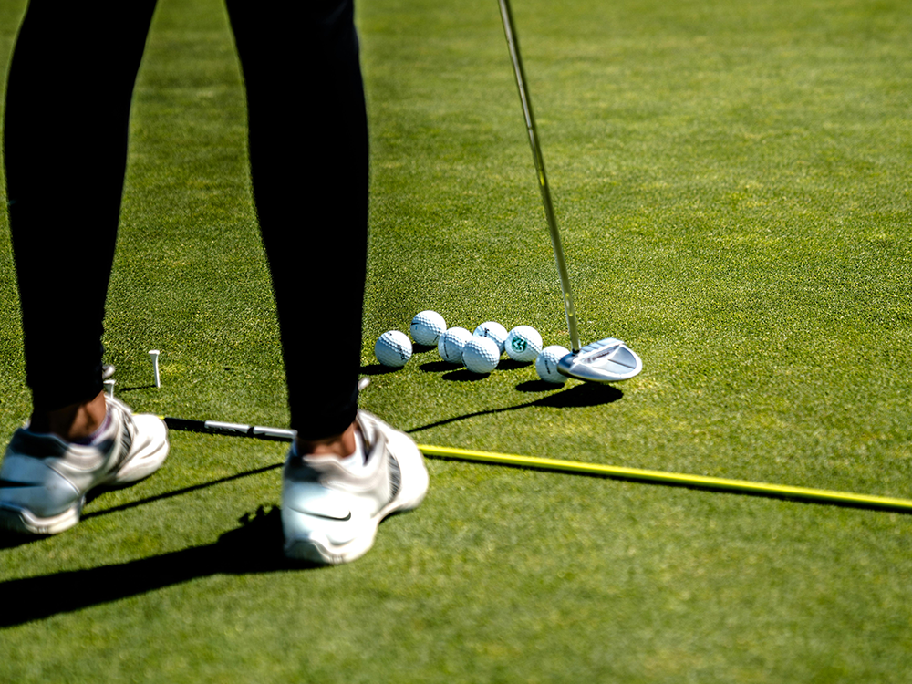 STOCK IMAGE - GOLFER PRACTICING WITH PUTTER